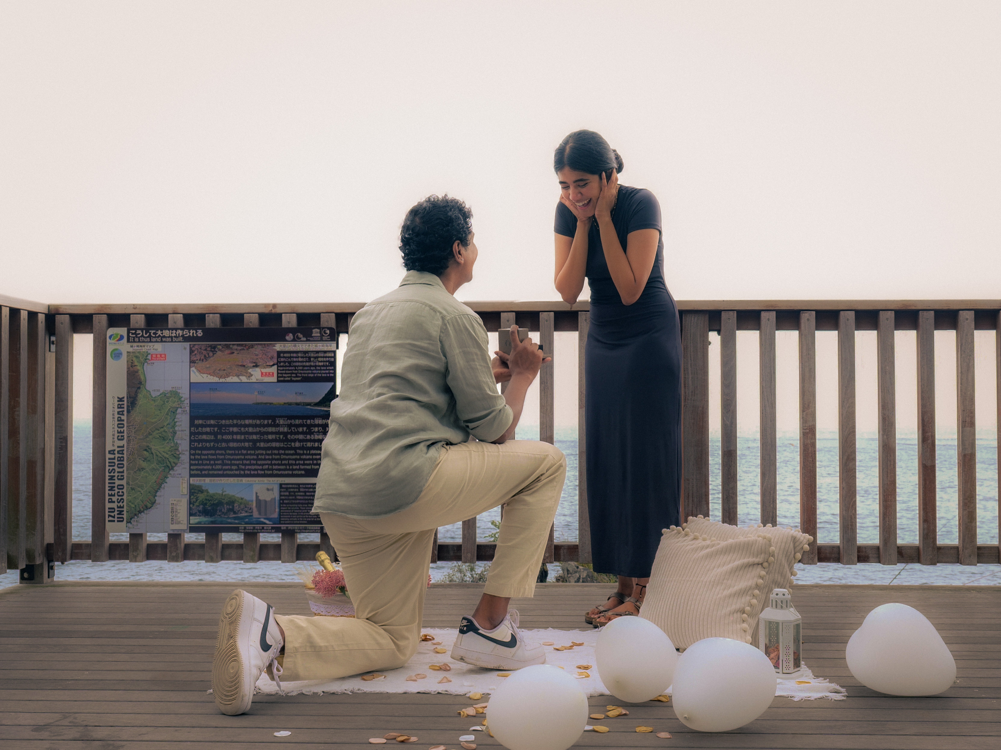 A proposal on a wooden deck overlooking the ocean.