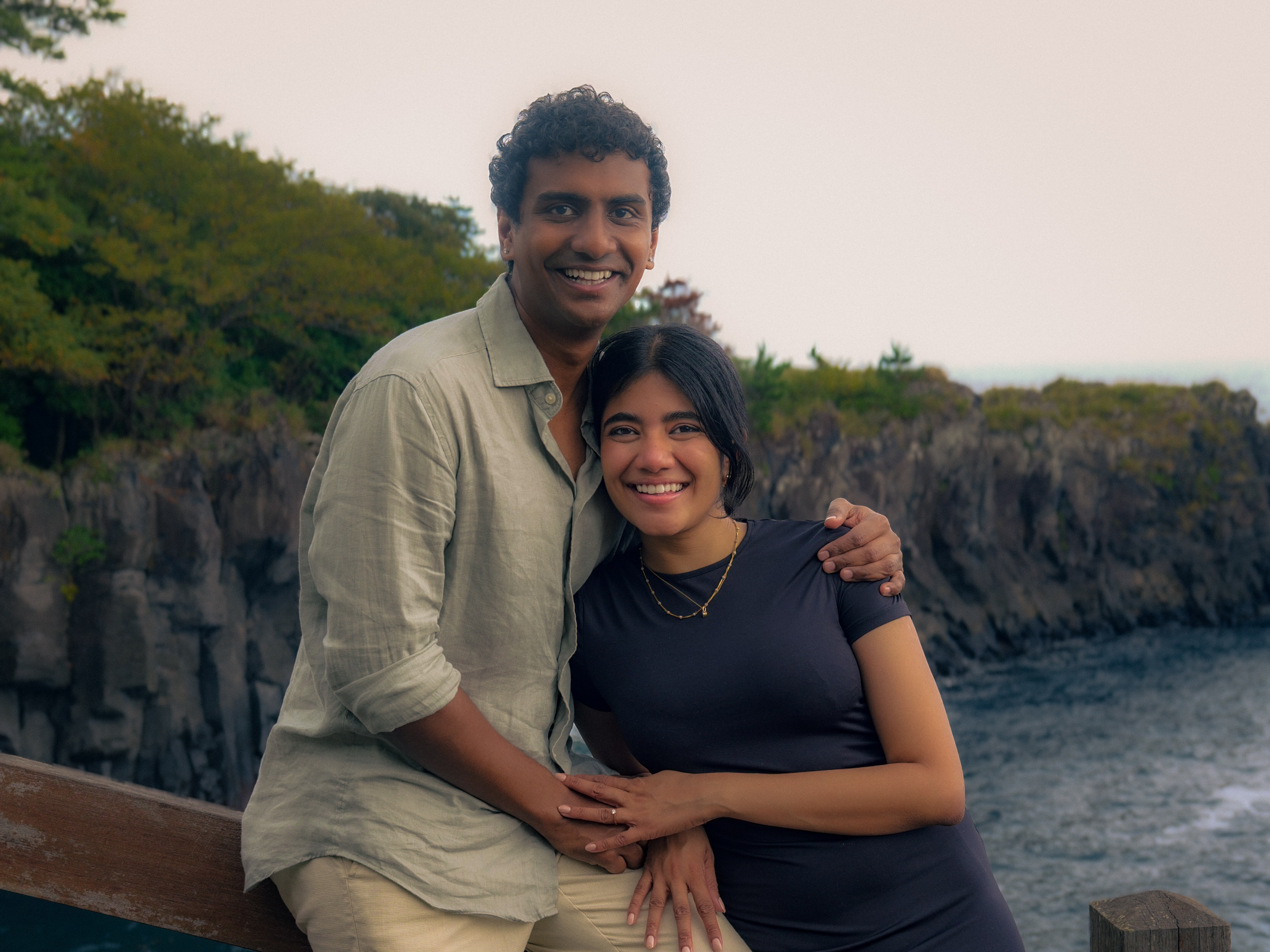 The couple smiling together above the cliffs.